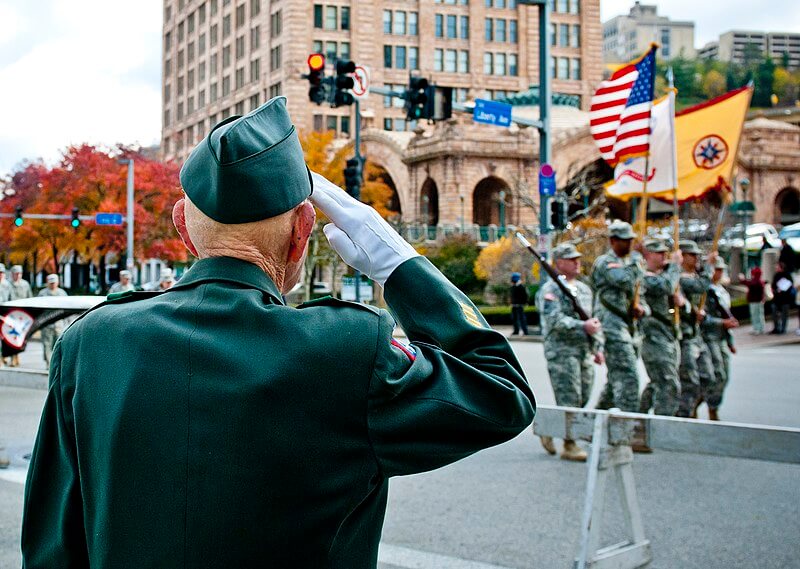 U.S. Army veteran saluting during a Veterans Day parade